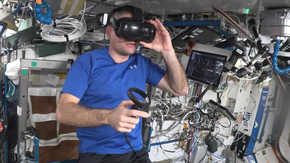 An astronaut wearing a vr headset in a crowded space station model